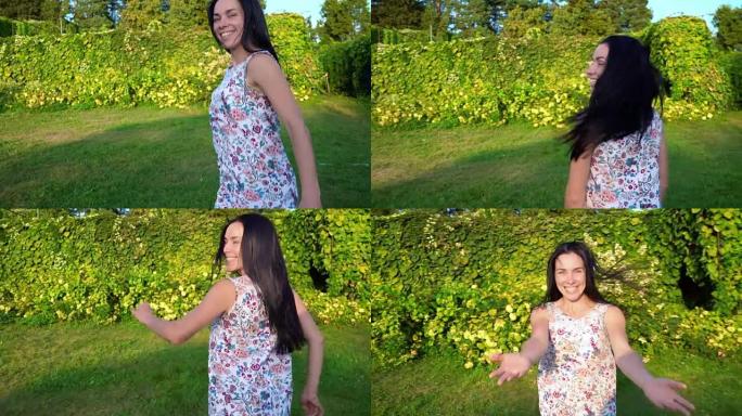 年轻女子在绿色的花园里嬉戏地围着自己转。一个微笑的黑发肖像，脸颊凹陷，对着绿色公园