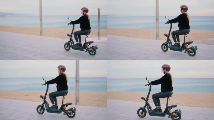 漂亮的金发女人在海边驾驶电动自行车。