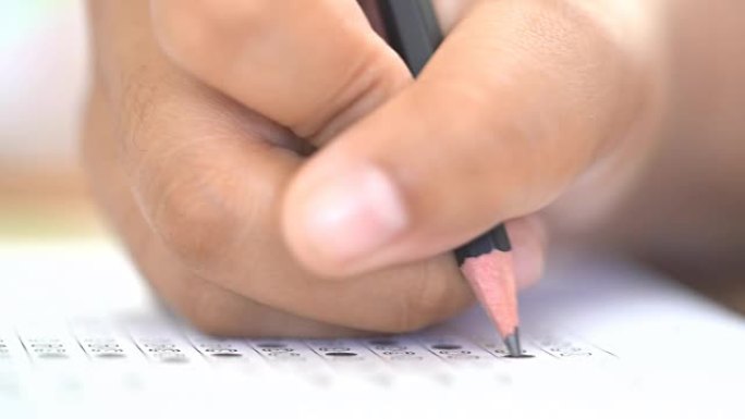 考试考试概念，考试答题纸上的特写铅笔，考试教室中学生的手笔。知识评价研究生教育评估的It多项选择