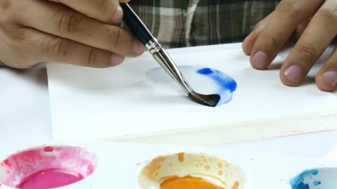 亚洲艺术家在白纸上手绘水彩