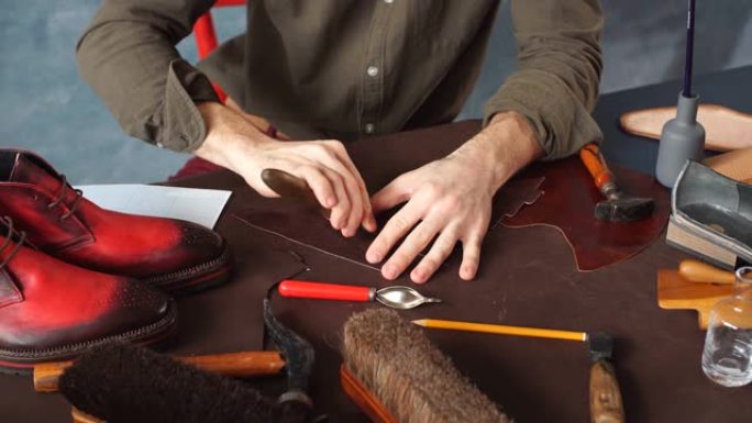 在车间用手工工具处理皮革的人。