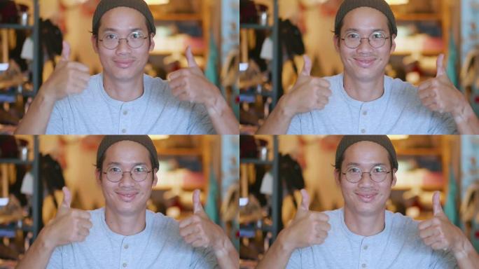 泰国男子的肖像对镜头微笑，年轻英俊的亚洲男子竖起大拇指。