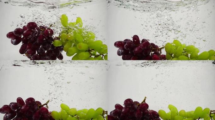红色和绿色葡萄的慢动作视频。一束成熟的葡萄被浸泡在带有气泡的水中。