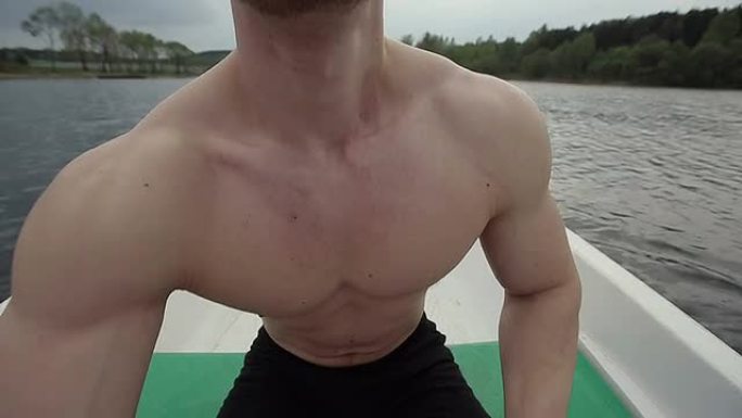 肌肉强壮的人漂浮在船桨上。
