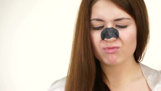 女人在鼻子上涂抹毛孔条