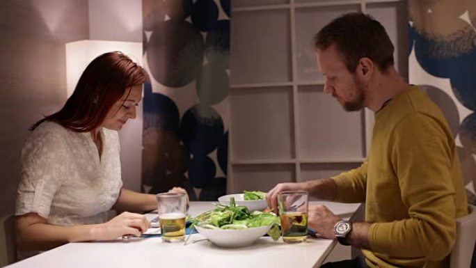 女人和男人在餐桌上吃饭和聊天。
