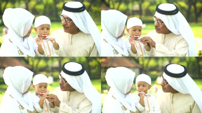 穆斯林儿子在公园吃最喜欢的糖果并与母亲分享