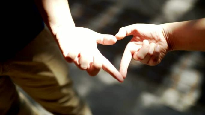 爱情情侣在街上用手塑造心形。