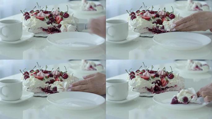 女性手切甜点，放在白色盘子里。浆果白蛋糕。巴甫洛夫的甜点