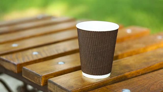 在夏季公园的长凳上喝杯拿铁咖啡