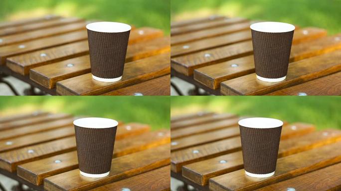 在夏季公园的长凳上喝杯拿铁咖啡