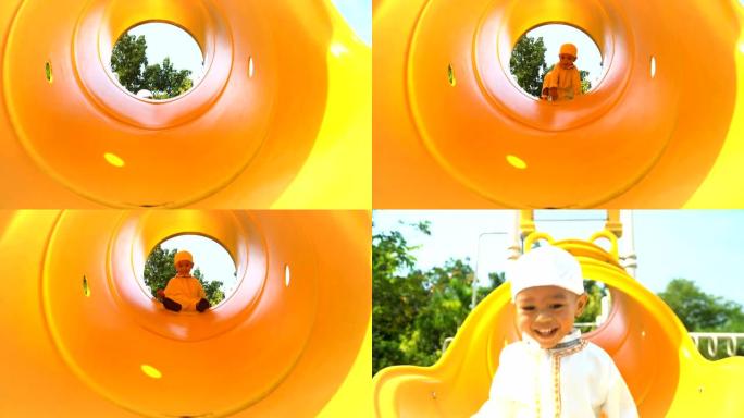 前视图: 穆斯林小男孩在黄色滑道上从上到下玩耍和微笑
