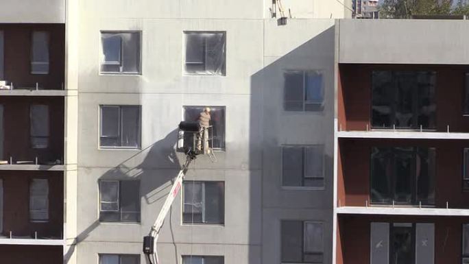 工人在平坦的公寓房屋墙壁上喷涂热漆