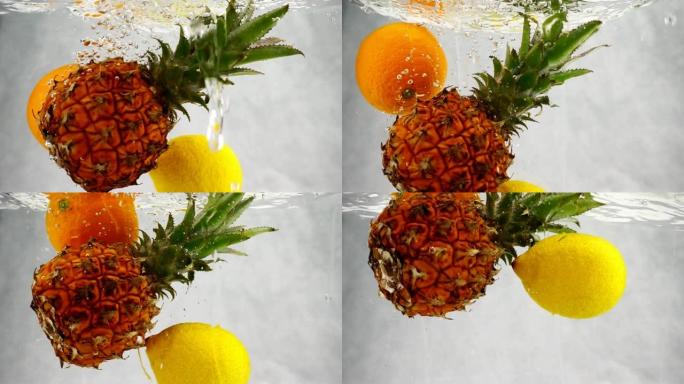 菠萝，橙子和柠檬以慢动作飞溅和气泡落入水中。
