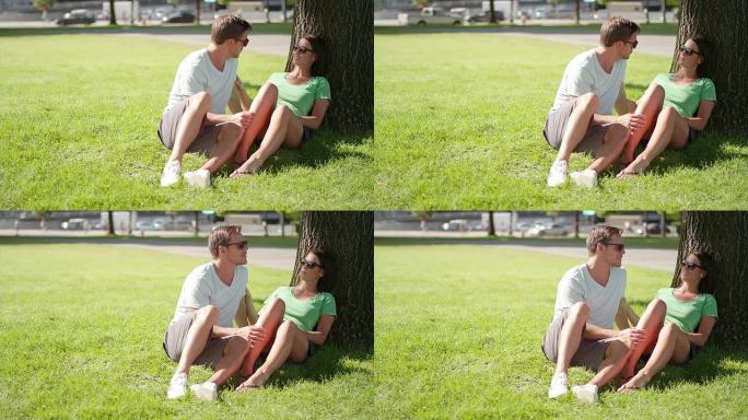 恋爱中的情侣坐在城市公园的树下