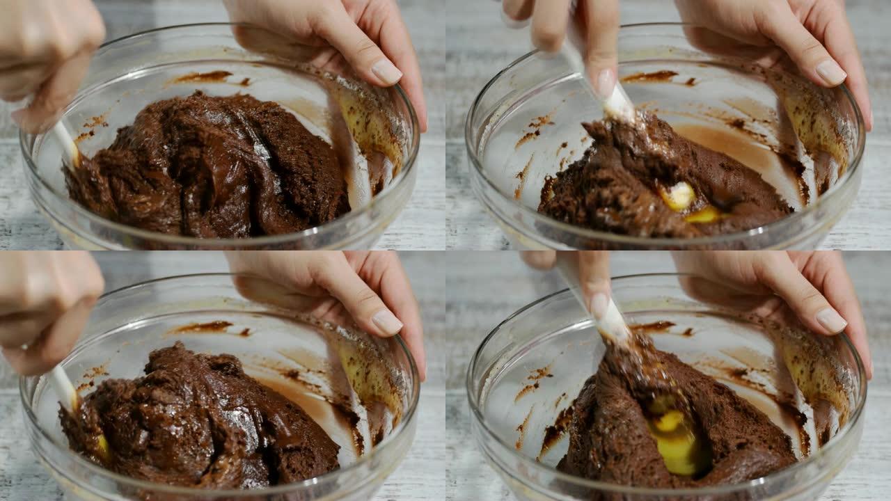 女孩用抹刀搅拌巧克力面团。制作巧克力面糊的过程。