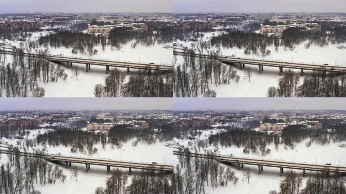 在美丽的城市或城镇下雪的冬天。夹。结冰的河流的俯视图，道路上的许多汽车，古老的建筑。大城市迷人的冬季