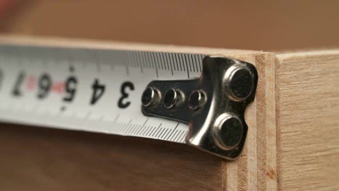 用卷尺测量胶合板的特写