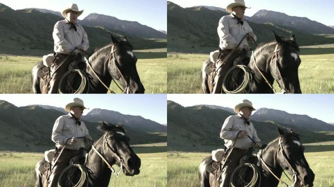 年迈的牛仔在山上骑着马，身后有一个旭日