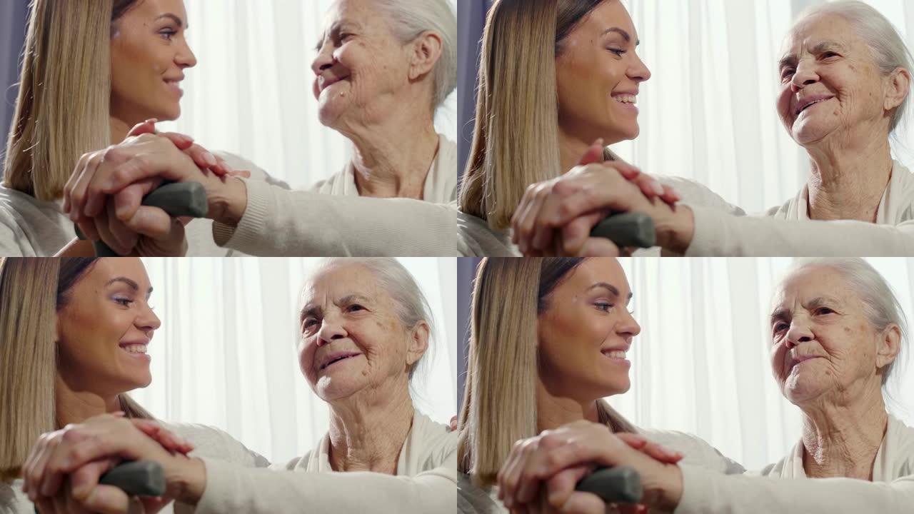 幸福的女人手牵着手和老祖母交谈