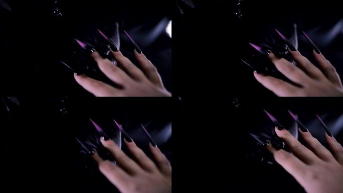 艺术家喷漆尖尖的紫色和黑色指甲