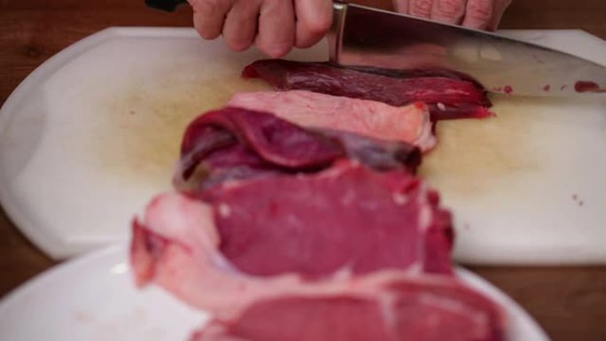 厨师用锋利的刀将牛肉侧面牛排切成薄片