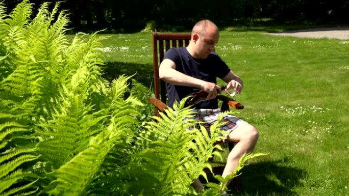 男子将塑料瓶中的啤酒倒入坐在木椅上的玻璃中。4K