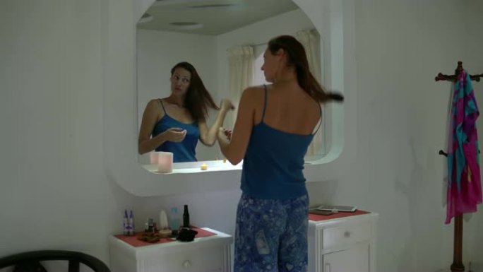 女人在镜子前用梳子梳理头发