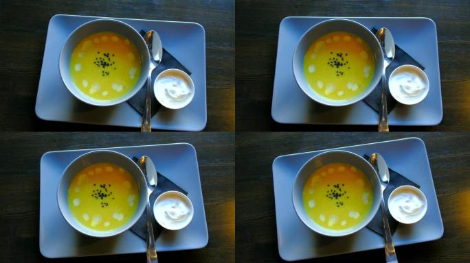 顶视图-服务员在餐厅的桌子上提供新鲜的南瓜汤。4k。