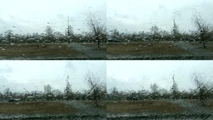 多雨的天气。窗户玻璃上雨滴的城市景观。