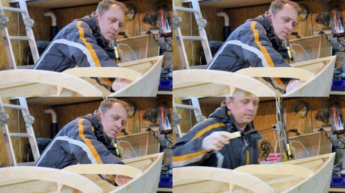 一个人收集木头制成的船。他从事体力劳动。