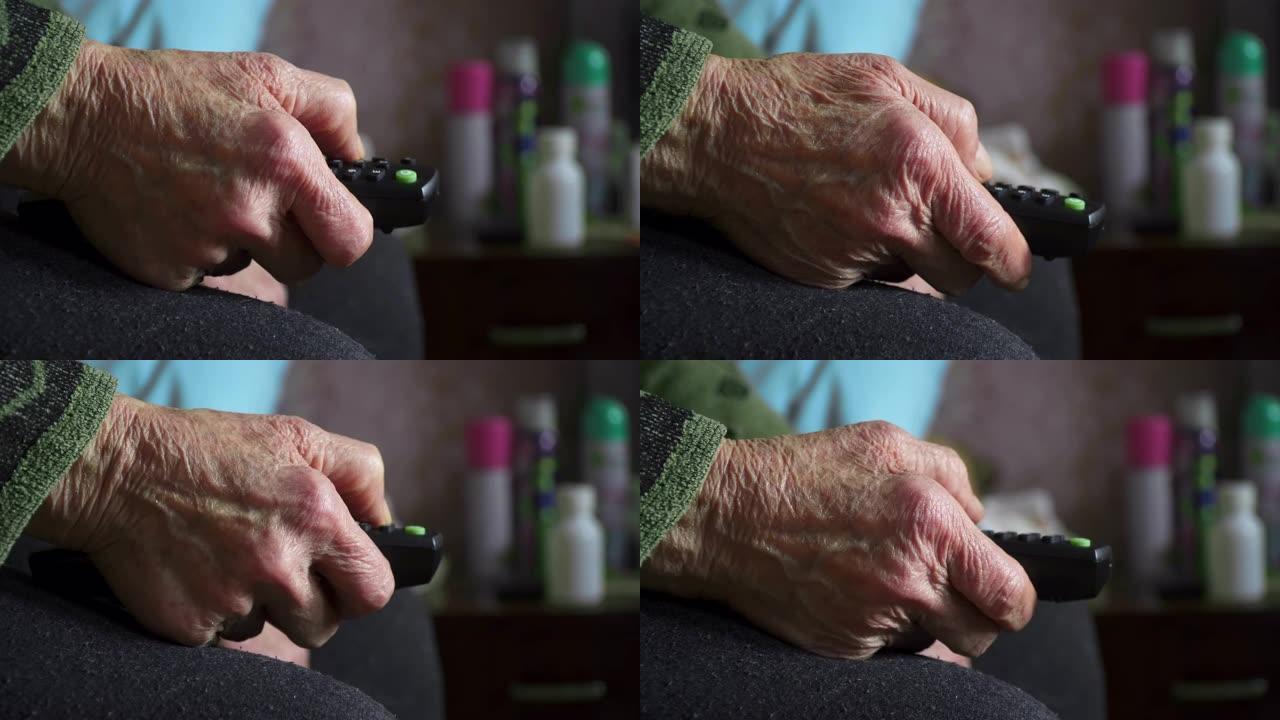 一位老人在看电视，娱乐，用遥控器关闭奶奶的满是皱纹的手。