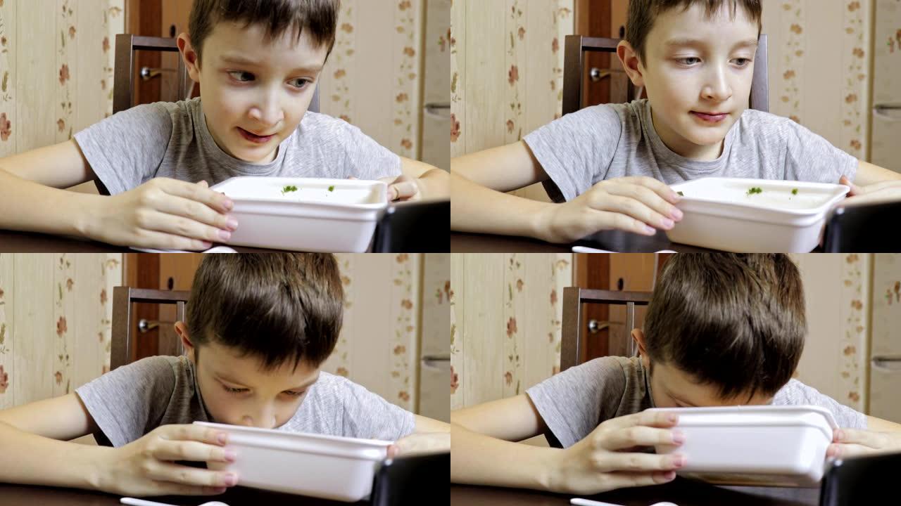 一个青春期的高加索男孩在家里吃中国快餐，一次性容器里的方便面，他的老鼠很脏