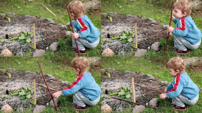 婴儿在火坑附近玩木棍