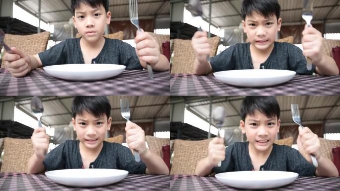 愤怒的亚洲孩子等待食物发射。
