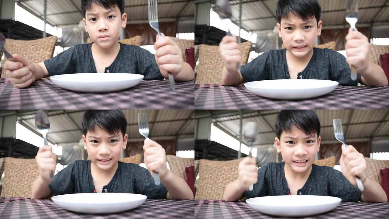 愤怒的亚洲孩子等待食物发射。