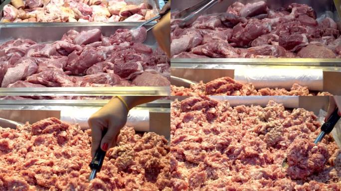 展示肉制品。女人的手用不锈钢手柄在超市选择生猪肉。