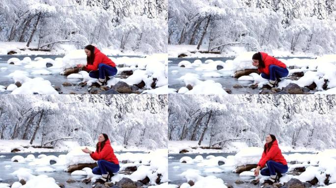 河岸上的女人，手里拿着冰水喝，享受冬天的风景。