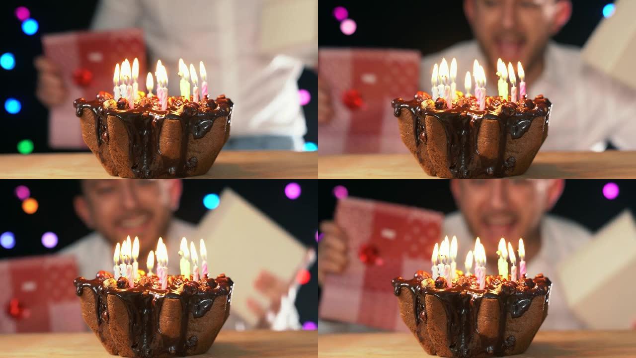 快乐的男人在家庆祝生日，并带着礼物跳舞。带蜡烛的生日蛋糕。4K