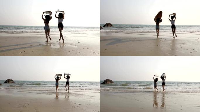 两个带冲浪板的女孩在海滩上玩得开心
