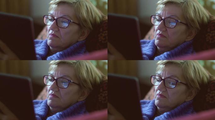 老年妇女在平板电脑上使用facebook: 眼镜上的反射