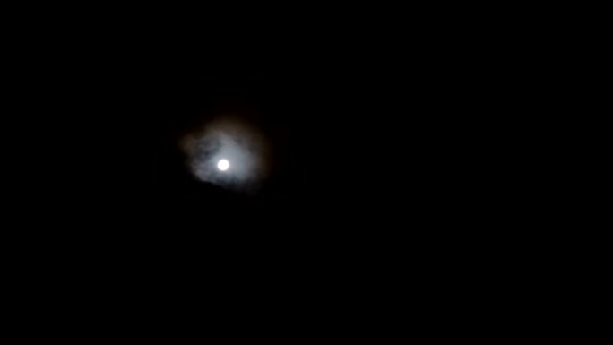 月球上许多快速移动的云层，几乎将其隐藏起来，并显示出它像太阳一样刺眼。
