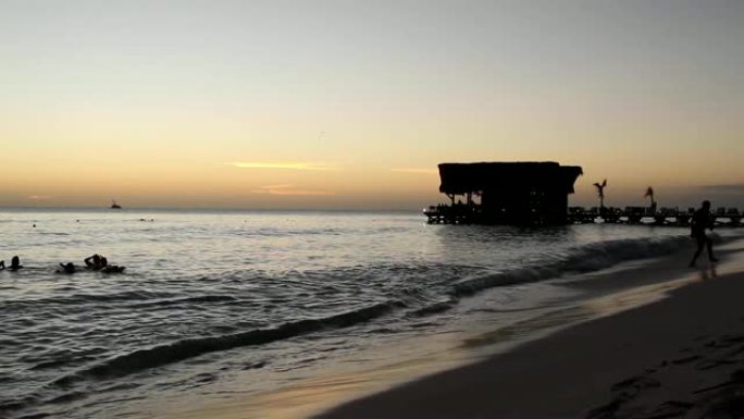 红色加勒比海日落，游泳者和酒吧剪影 -- 热带度假概念