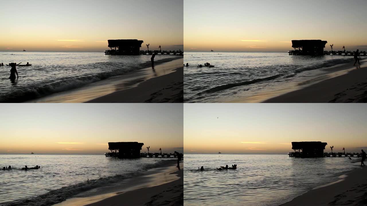 红色加勒比海日落，游泳者和酒吧剪影 -- 热带度假概念