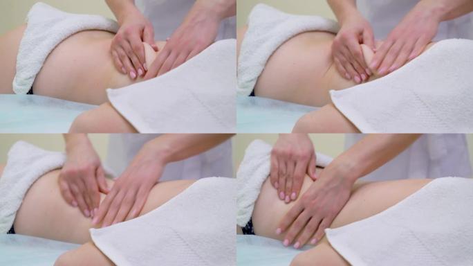 按摩师手在年轻女子背部做消脂按摩的特写镜头