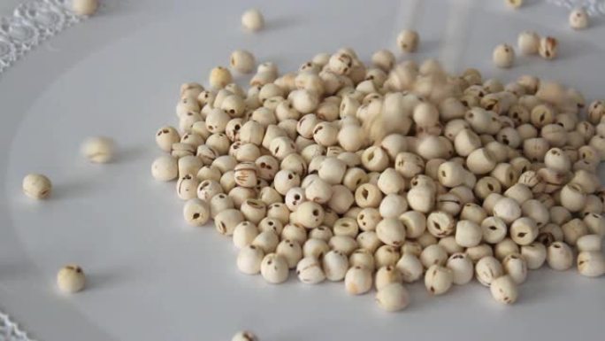 莲子或莲子 (lat.Nelumbo nucifera)，种子落在桌子上。用于亚洲美食和传统医学。大
