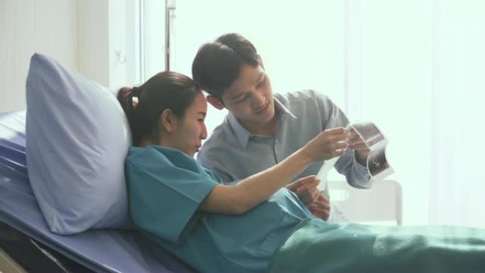 侧视图: 年轻的丈夫和怀孕的妻子在超声图像上看到他们的孩子时的幸福时刻
