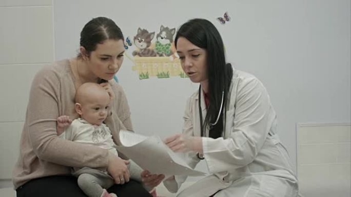 女儿科医生向婴儿较小的妇女展示了一些论文