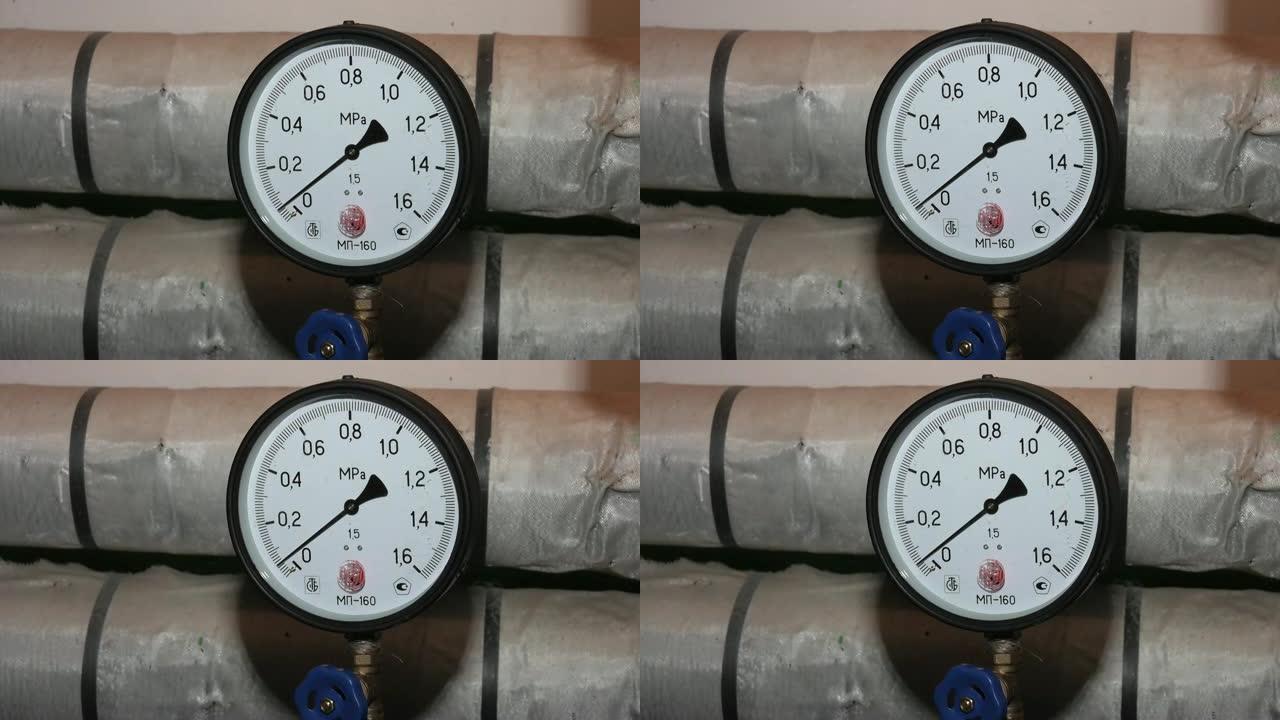 管道上的圆形机械压力表。现代工业锅炉房。带有许多钢管，压力计和金属管的房屋供暖系统。加热系统。水泵、