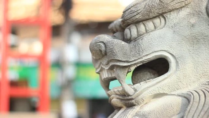 平移显示的镜头显示，在东南亚中国城镇地区的门口，传统的中国狮子站岗